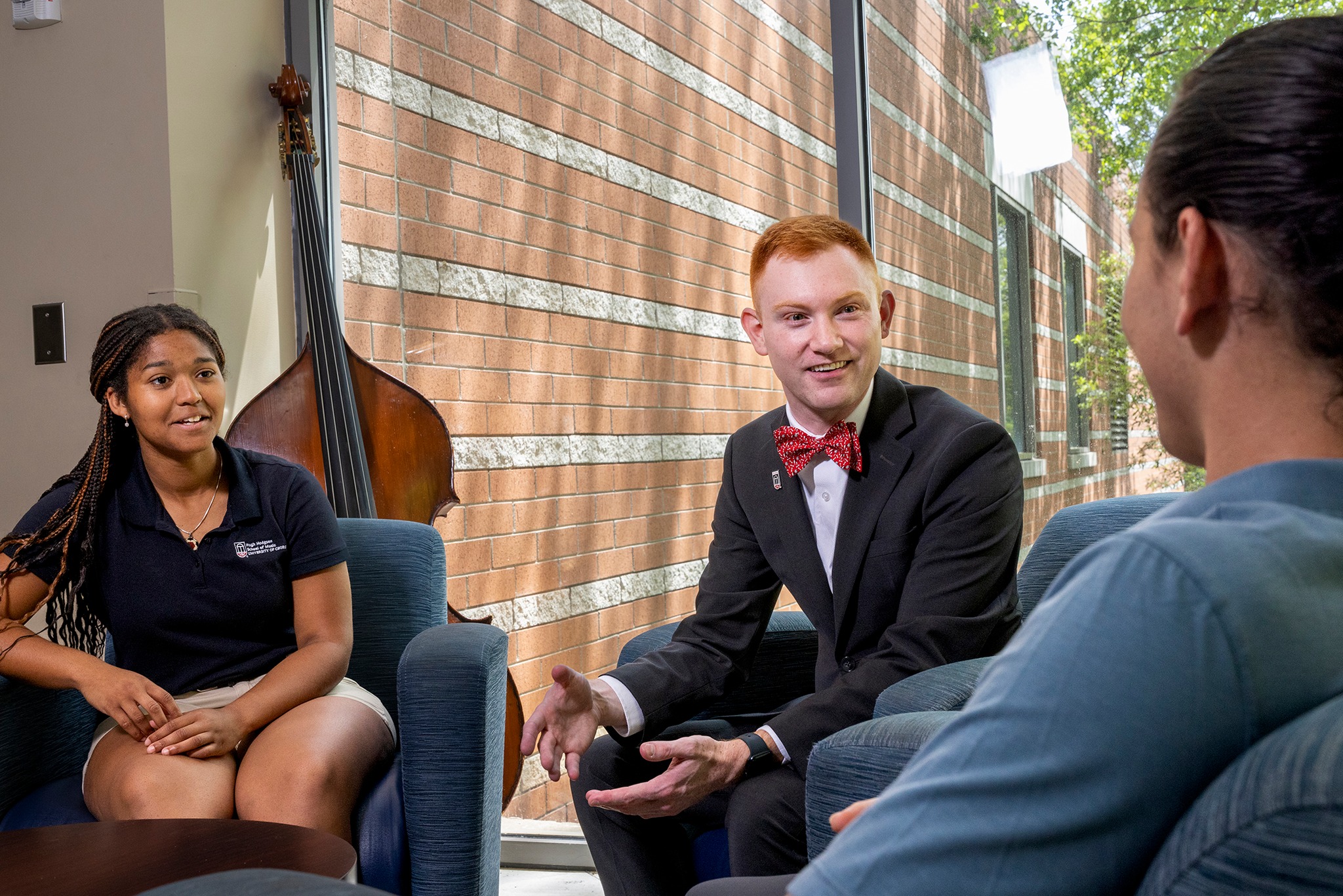 Undergraduate students Bianca Wilson, left, and Trey Heaton, right, chat with Marshall Williams, center, in the Hugh Hodgson School of Music building.
