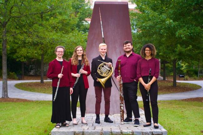 The Southern Wind Quintet standing in a semi-circle in front of a sculpture